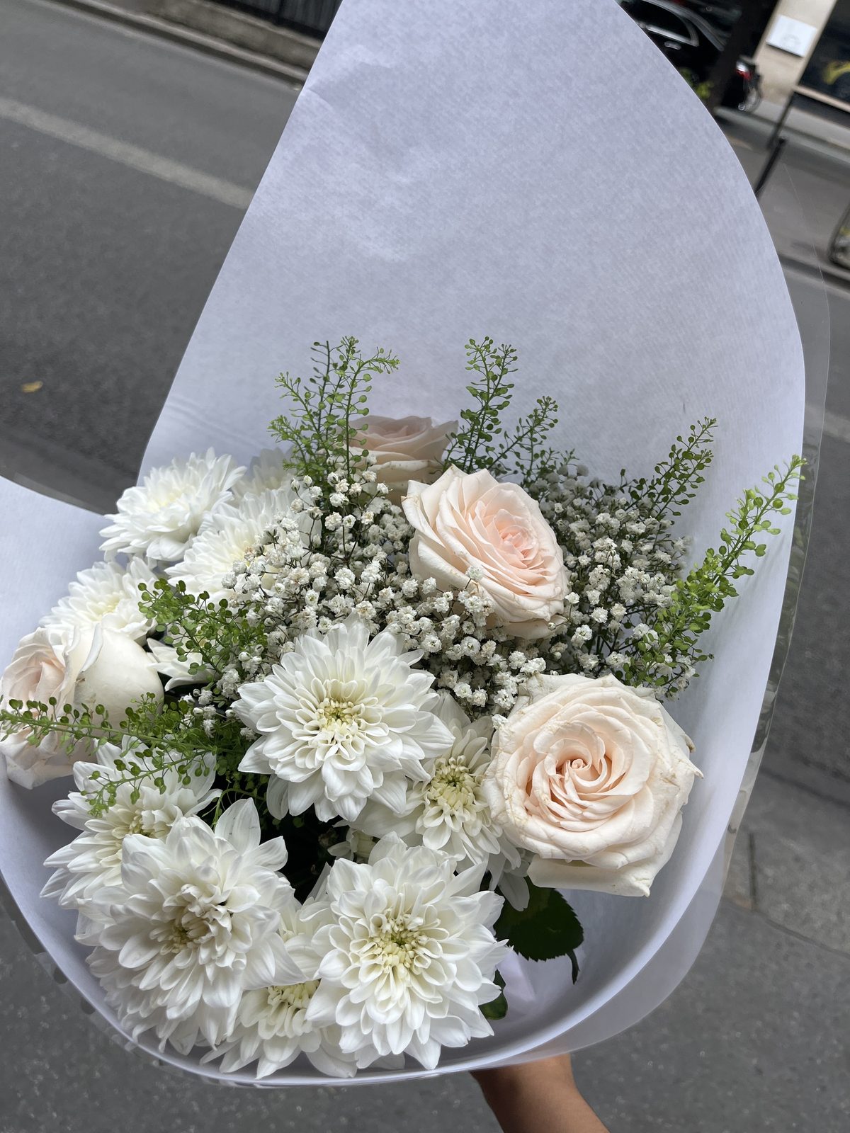 Bouquet blanc et rose pâle, roses et chrysanthèmes, dans un papier blanc
