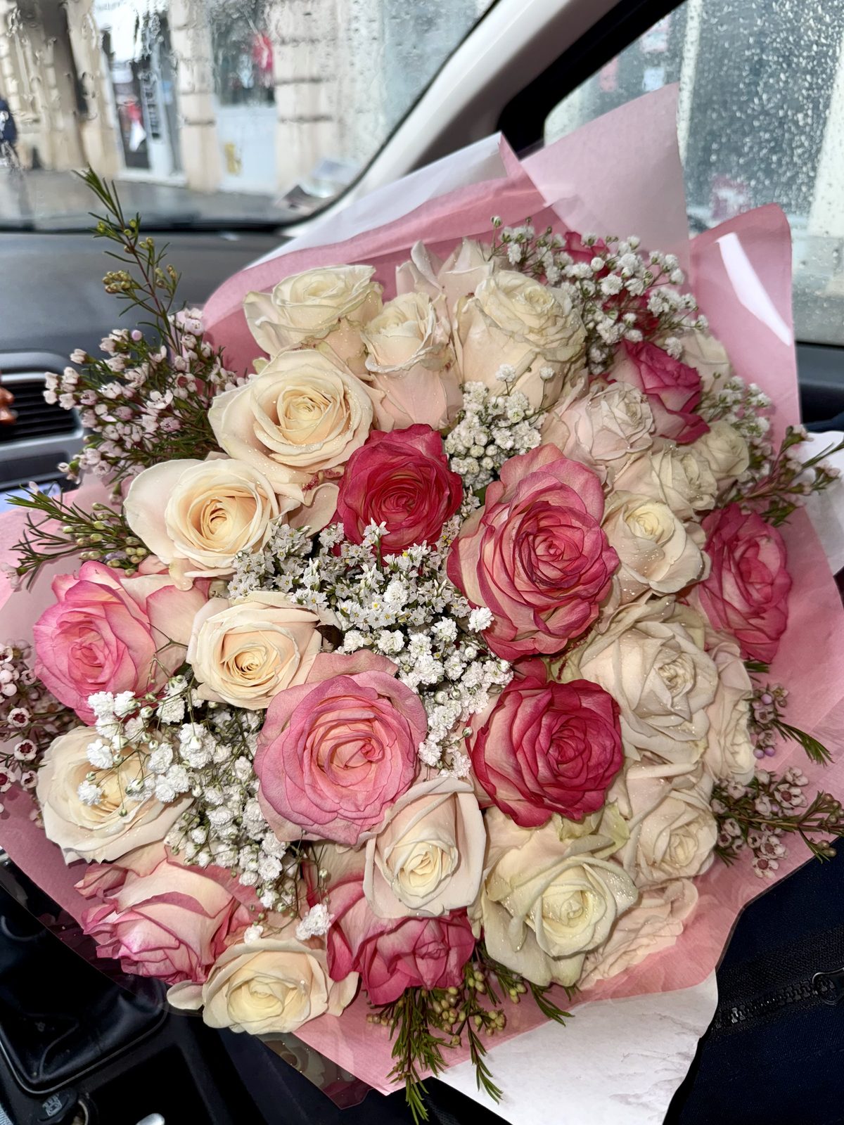 Bouquet de roses roses et crème dans un papier rose